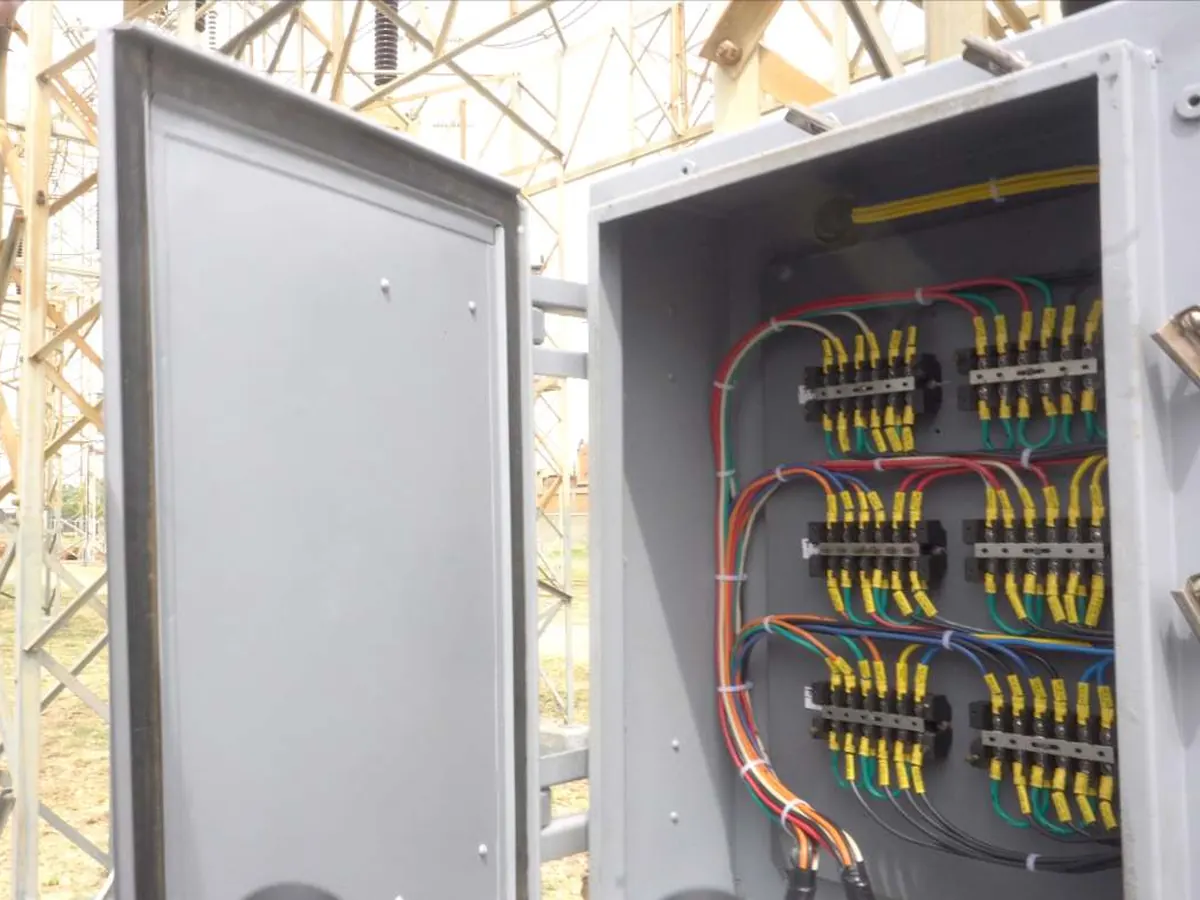 Caja de contactos auxiliares rehabilitada, con el cableado ordenado y marquillas, en el patio de una subestación