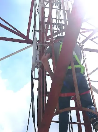 Técnico con arnés en el ascenso a la torre